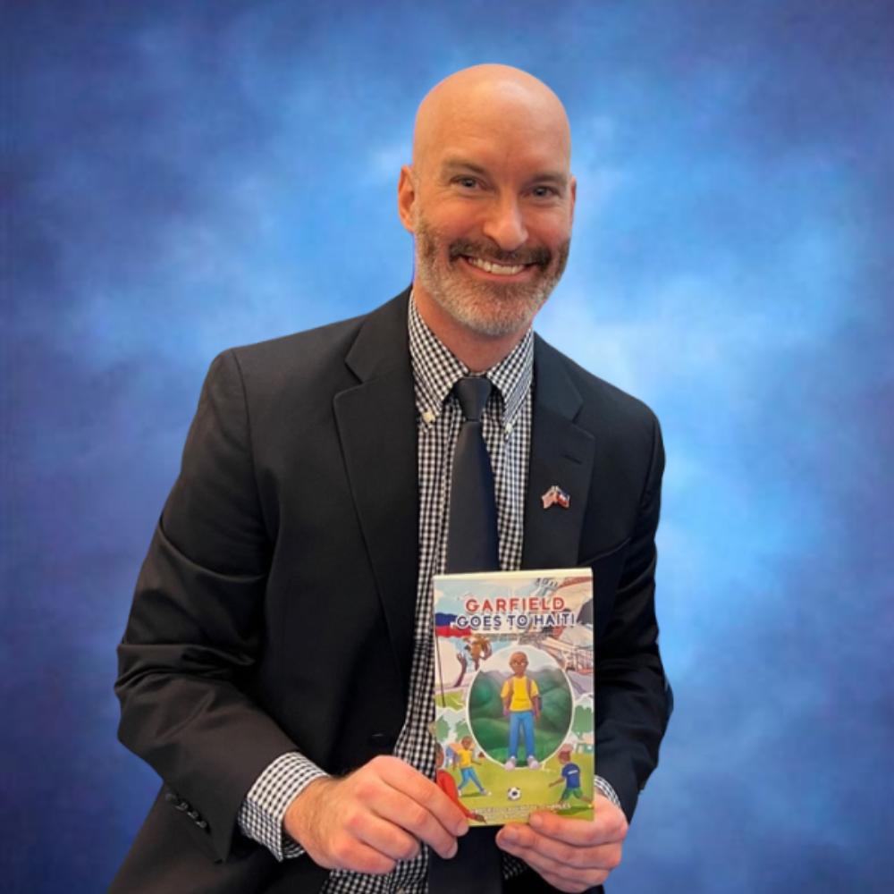Man holding "Garfield Goes to Haiti"
